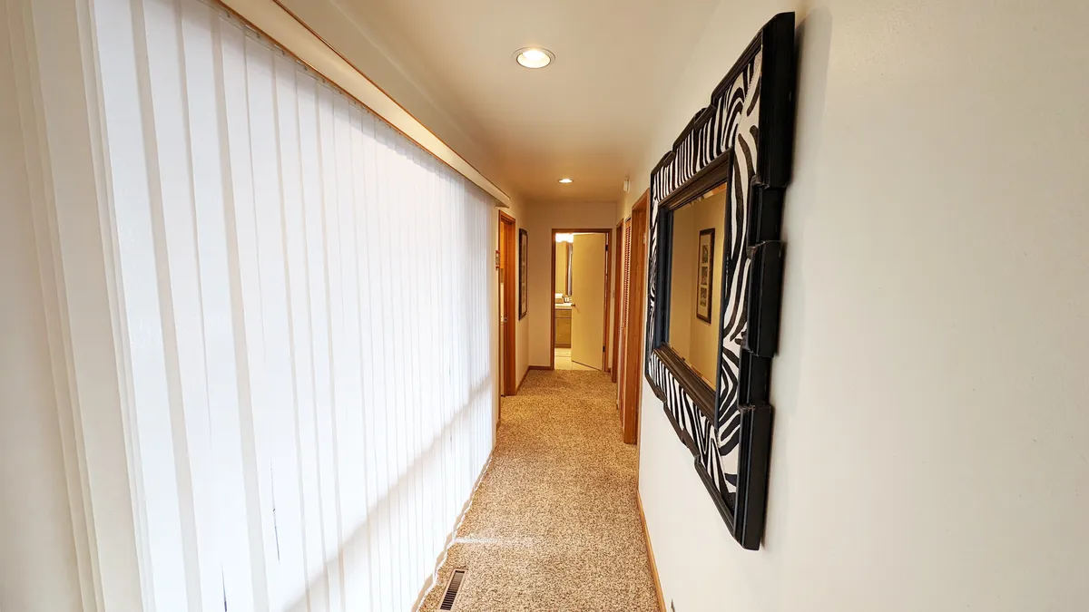 A bright hallway illuminated by natural light features a zebra-striped mirror and welcoming atmosphere. This area evokes first impressions and the anticipation of arrival, echoing the section's focus on setting out for, and returning from, daily adventures.