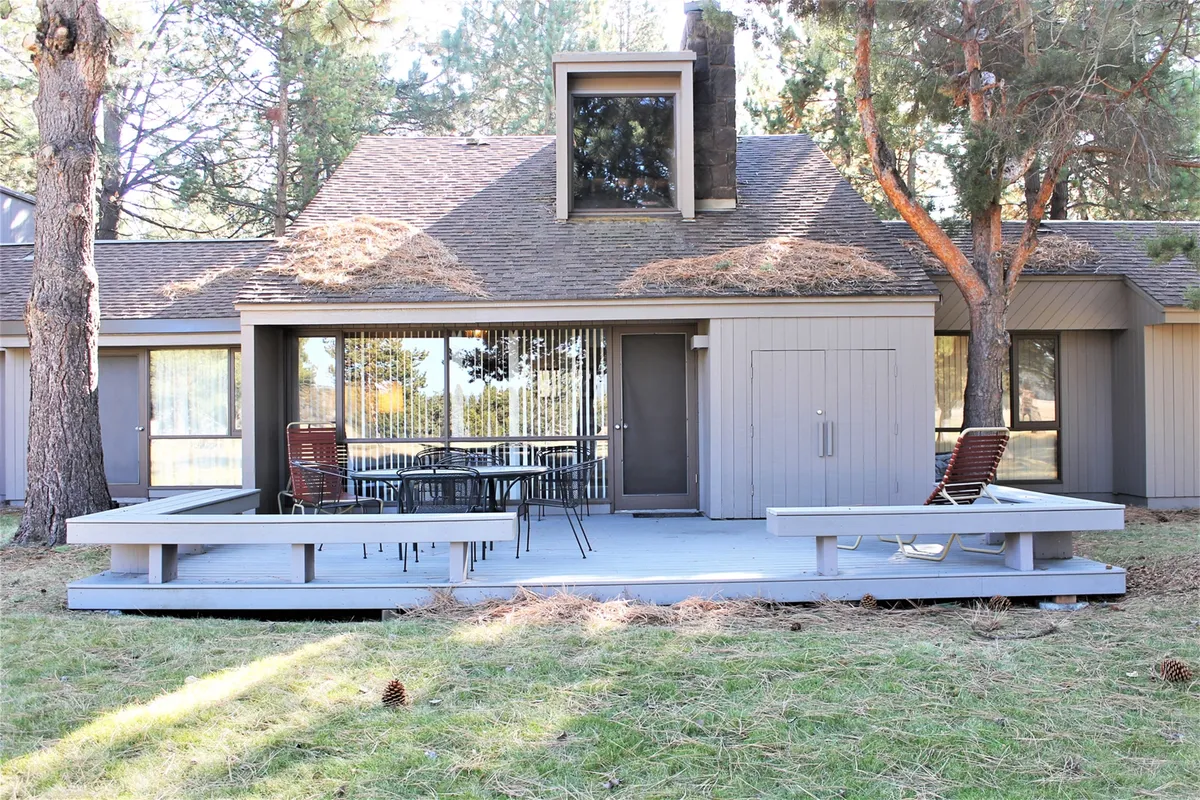 A peaceful deck area with a table and chairs positioned to enjoy the surrounding trees. The deck feels expansive and open, inviting guests to enjoy meals, morning coffee, or tranquil moments while taking in the meadow and golf course views.